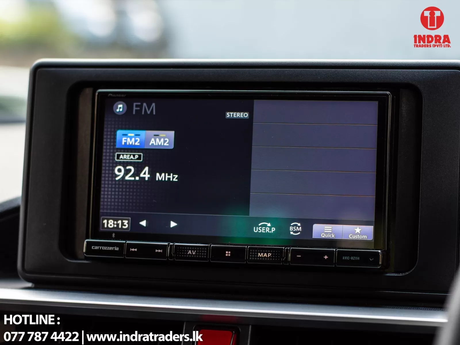 In-car touchscreen showing FM radio at 92.4 MHz with stereo mode and FM2/AM2 options, Indra Traders logo visible top-right