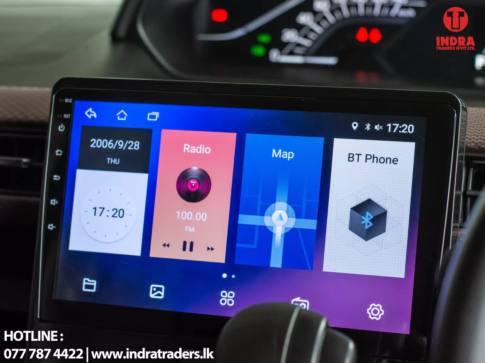 In-car infotainment touchscreen showing tiles for Radio (100.00 FM), Map, BT Phone, and a clock displaying 17:20, with Indra Traders logo top-right.
