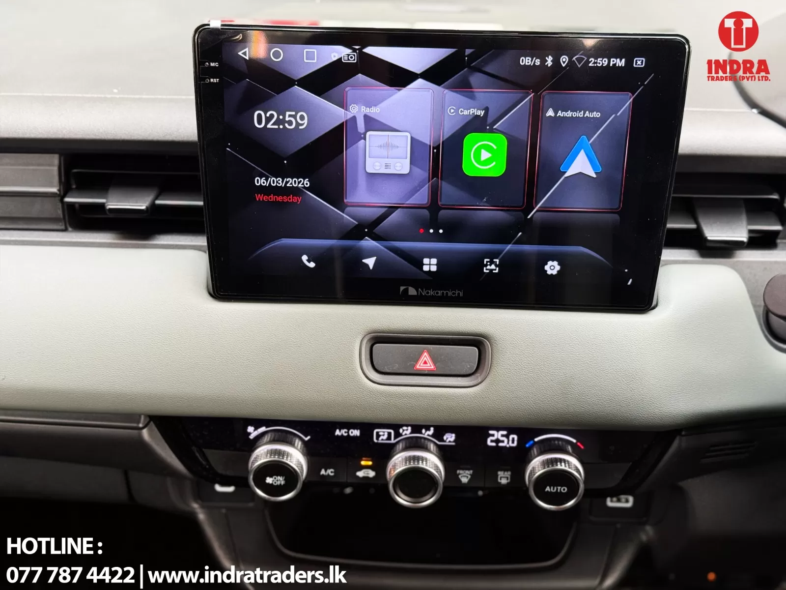 Car infotainment touchscreen mounted on the dashboard showing apps (Radio, CarPlay, Android Auto) with climate controls below and a hazard button in front.