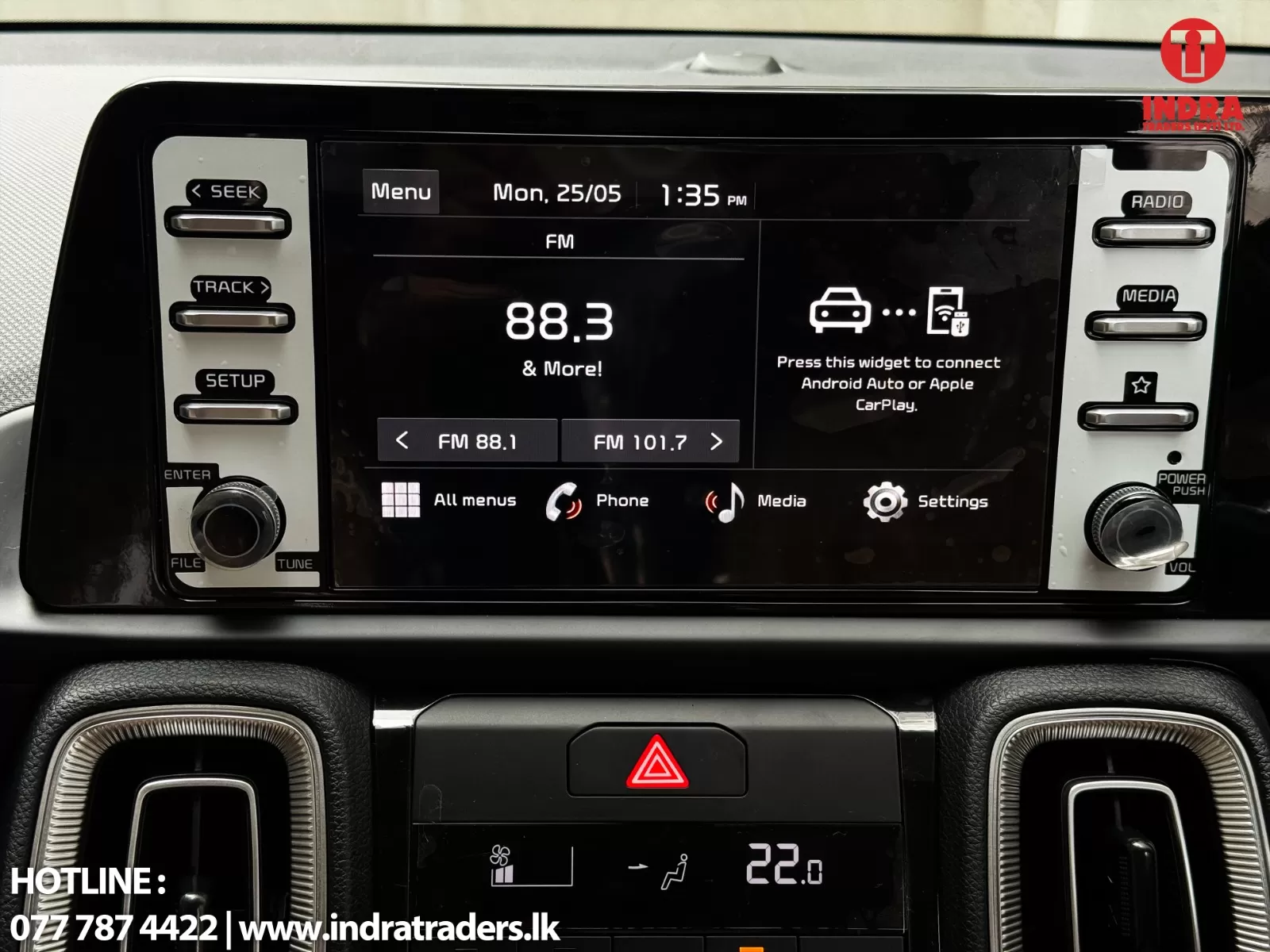 Car infotainment screen showing FM radio at 88.3 with side control buttons and app icons for All menus, Phone, Media, Settings.