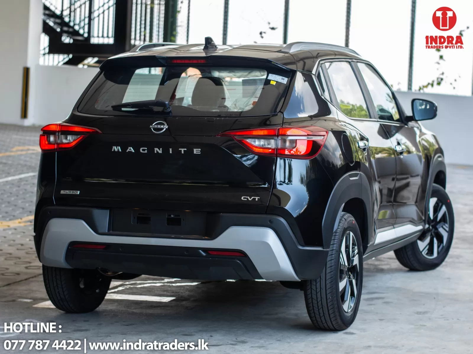 Rear view of a black Nissan Magnite SUV indoors, with 'MAGNITE' on the tail and Indra Traders logo in the corner (top right).