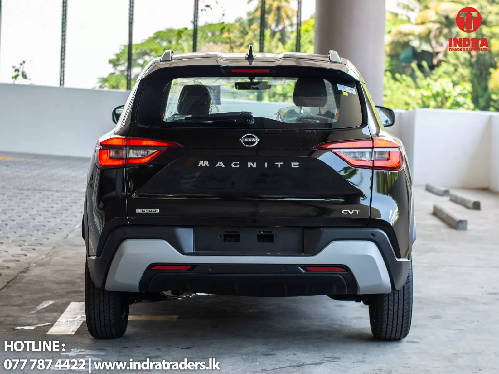 Rear view of a black Nissan Magnite SUV in a parking area; Indra Traders watermark top-right.