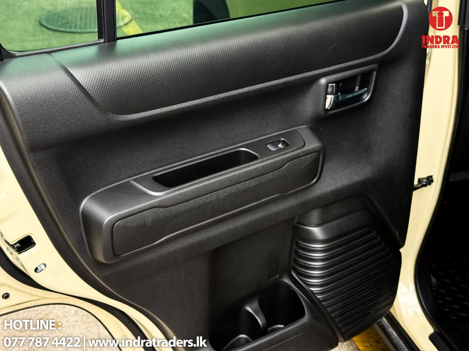Driver-side car door panel with textured upper trim, window switch, and a recessed storage pocket