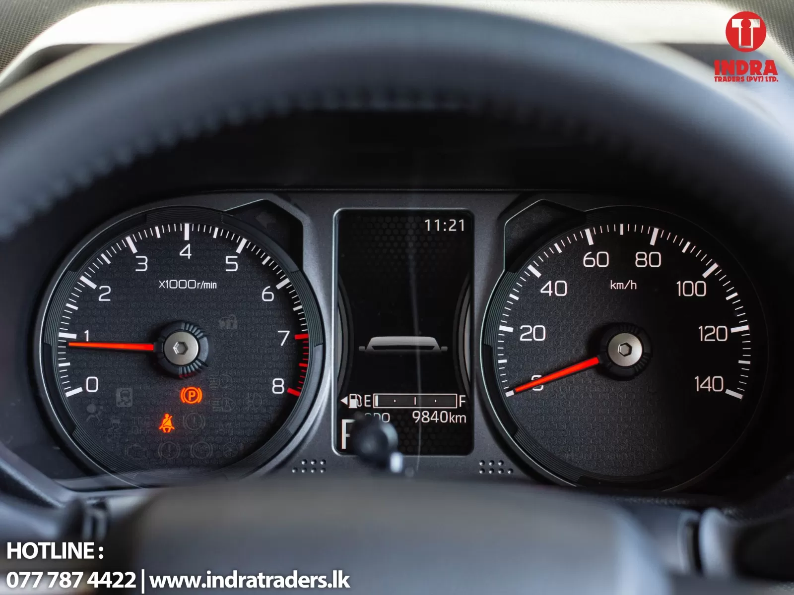 Close-up of a car dashboard showing the tachometer and speedometer with a central display reading 11:21 and 9840 km.