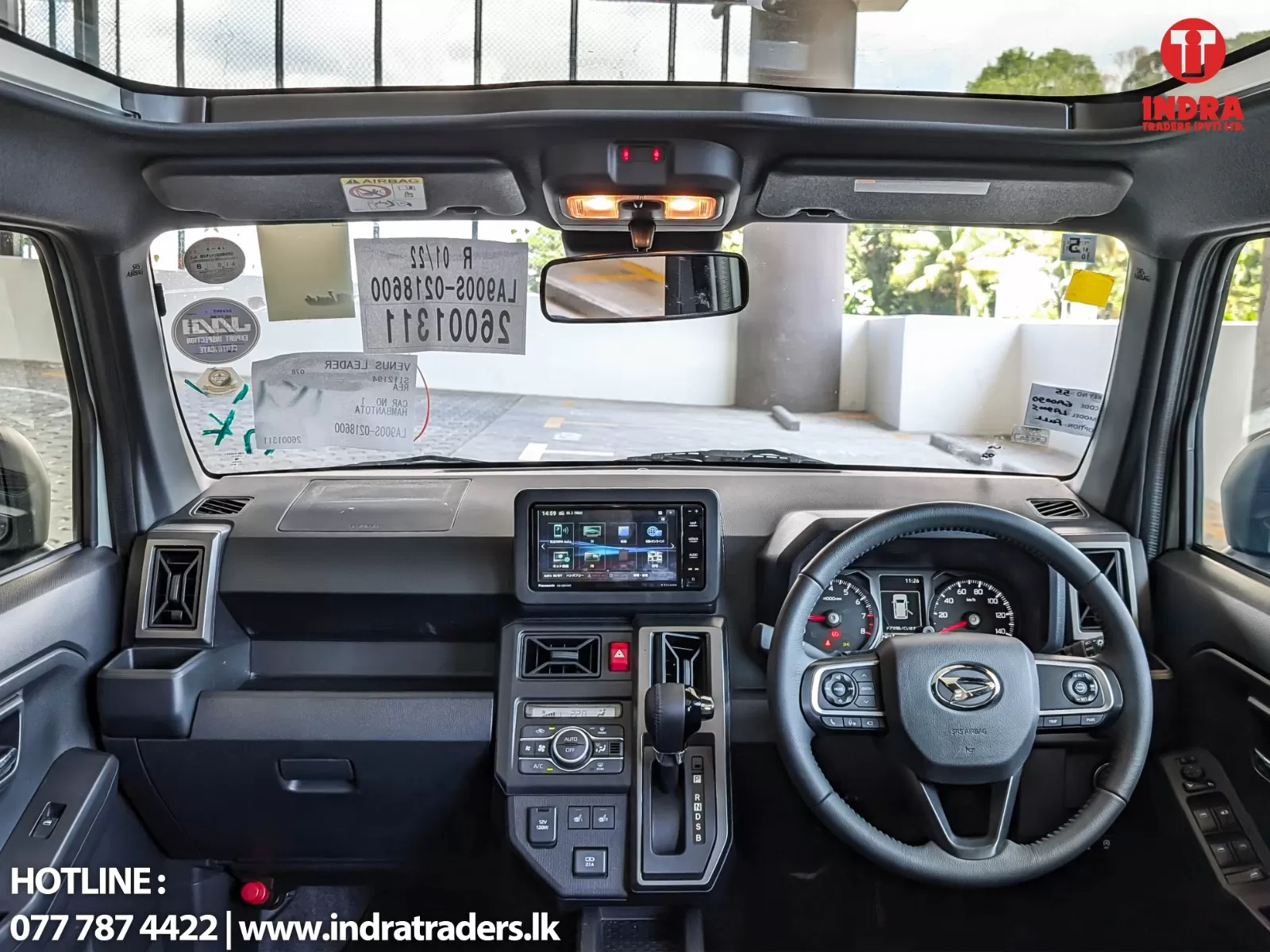 Right-hand-drive SUV cockpit with steering wheel on the right, central touchscreen, and overhead console lights visible.