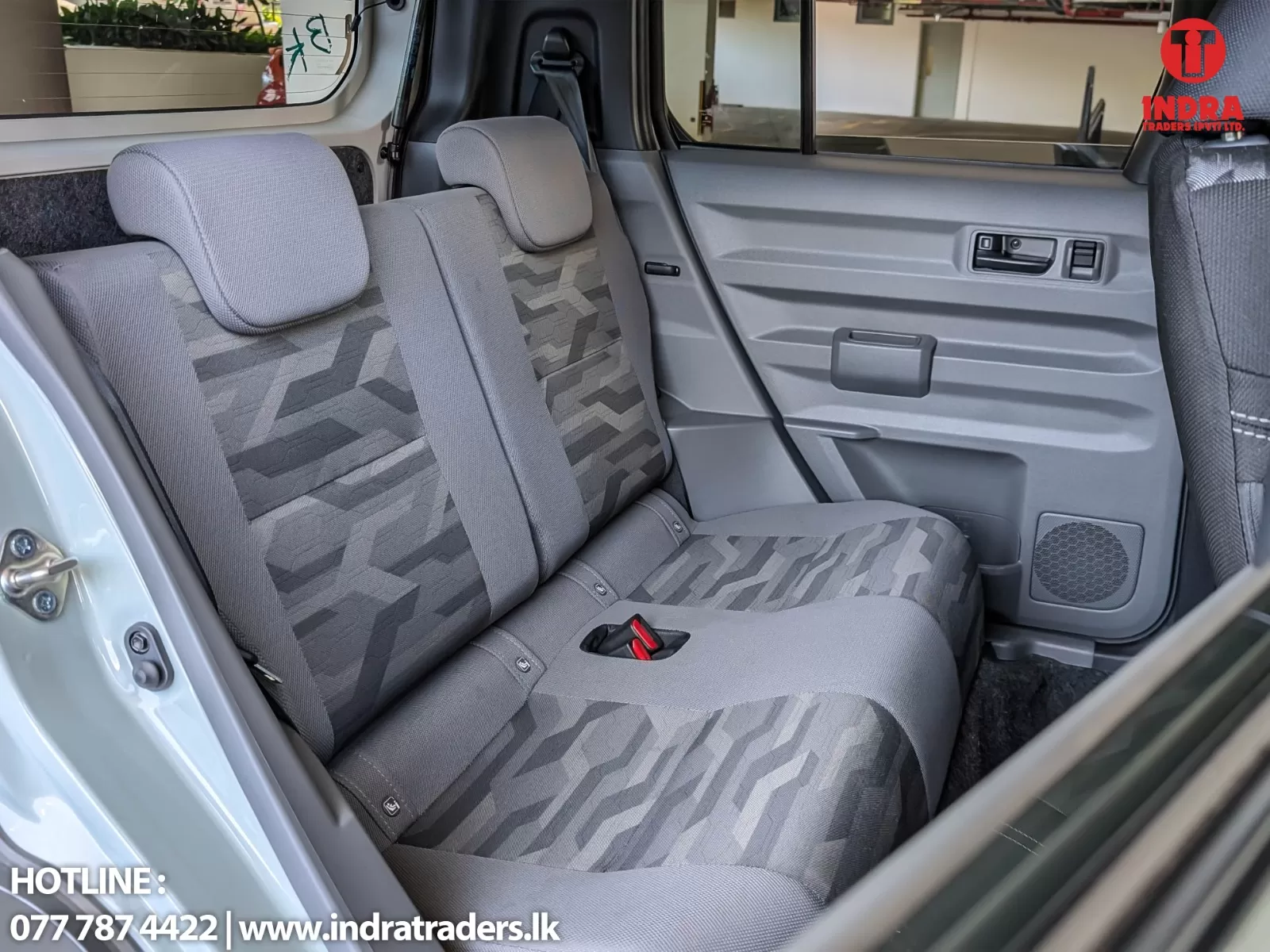Rear passenger seats of a gray SUV with patterned fabric, headrests, and a door panel.