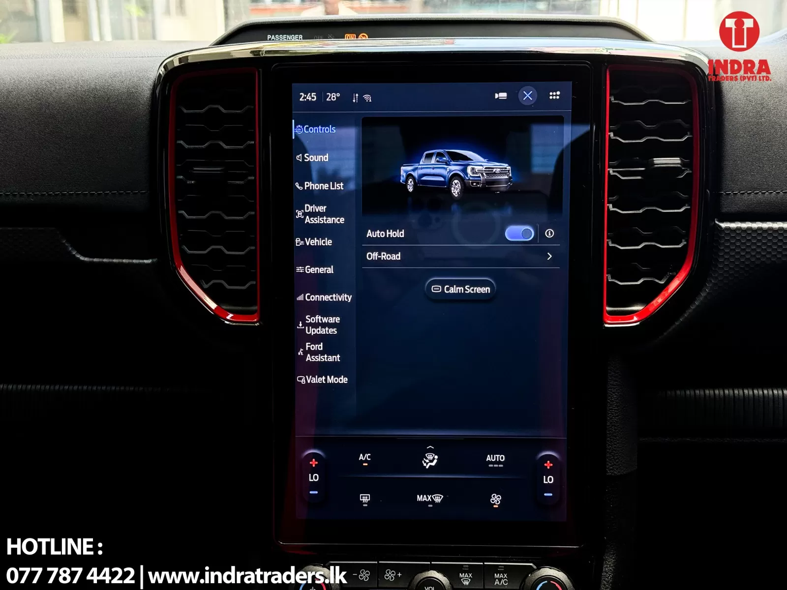 Infotainment touchscreen in a car showing vehicle controls (Auto Hold, Off-Road) with red-accented air vents on both sides and climate controls below.