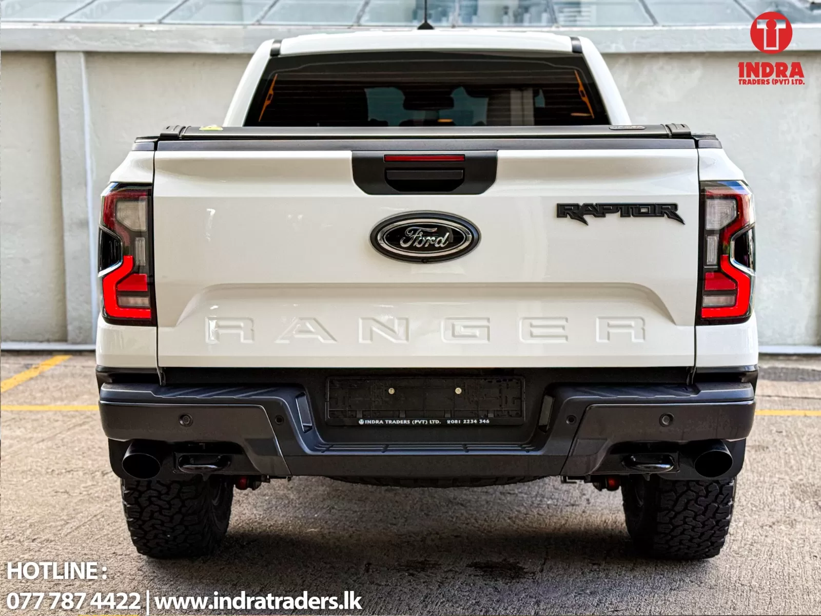 Rear view of a white Ford Ranger Raptor with the Ford emblem centered and 'RANGER' embossed on the tailgate; Indra Traders logo in the top-right corner.