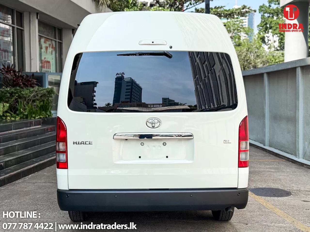 Rear view of a white Toyota Hiace van with Indra Traders logo in the top-right corner.